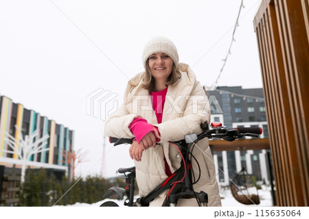 Woman Standing Next to Bike in Snow Woman Standing Next to Bike in Snow 115635064