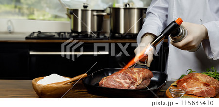 Chef cooking with meat burner. 115635410