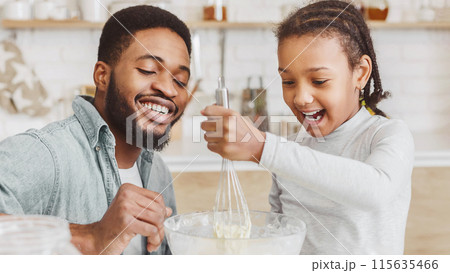 Cheerful Black Dad Teaching Lovely Daughter How To Make Dough, kitchen interior, panorama Cheerful Black Dad Teaching Lovely Daughter How To Make Dough, kitchen interior, panorama 115635466