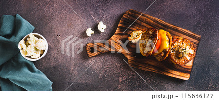 Homemade keto burgers on cauliflower fritters on a board top view web banner 115636127