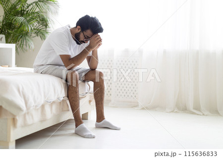 Portrait Of Depressed Young Indian Man Sitting On Bed At Home, Upset Millennial Eastern Guy Burying Head In Hands, Suffering Life Problems Or Mental Breakdown, Feeling Despair, Copy Space Portrait Of Depressed Young Indian Man Sitting On Bed At Home, Upset Millennial Eastern Guy Burying Head In Hands, Suffering Life Problems Or Mental Breakdown, Feeling Despair, Copy Space 115636833