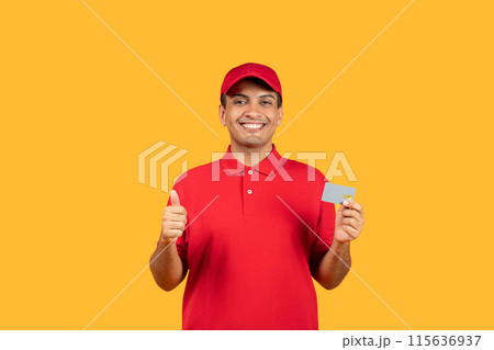 A cheerful delivery man dressed in a red uniform and cap gives a thumbs up while holding a card, standing against a bright yellow background. 115636937