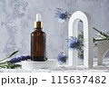 Glass dropper bottle with natural cosmetic on podium. Product presentation mock up. Beauty and body care product concept. Nature oil skin concept. Organic Spa Cosmetics. Blue flowers and concrete 115637482