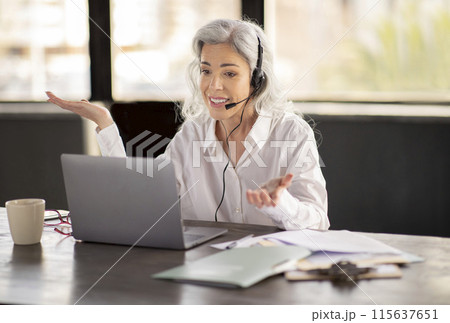 Customer Support. Hotline Operator Business Lady Making Video Call Wearing Headset And Talking To Computer At Workplace, Assisting Customers Online, Solving Client Issues Through Communication Customer Support. Hotline Operator Business Lady Making Video Call Wearing Headset And Talking To Computer At Workplace, Assisting Customers Online, Solving Client Issues Through Communication 115637651