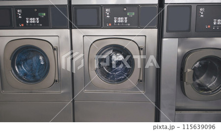 Public Laundry Service. Background With Three Industrial Washing Machines In Laundromat Room Standing In A Row Indoors. Laundrette Equipment And Technology Concept. Panorama Public Laundry Service. Background With Three Industrial Washing Machines In Laundromat Room Standing In A Row Indoors. Laundrette Equipment And Technology Concept. Panorama 115639096