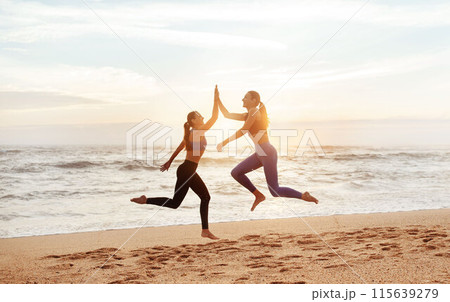 Glad young caucasian women enjoy morning workout, have fun, give high five, jump, freeze in air on sea beach. Good result in sports, lifestyle and body care, win and vitality outdoor Glad young caucasian women enjoy morning workout, have fun, give high five, jump, freeze in air on sea beach. Good result in sports, lifestyle and body care, win and vitality outdoor 115639279