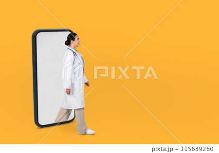 A medical professional lady dressed in a white lab coat and stethoscope walks through a large smartphone frame against a vibrant yellow background, the concept of telemedicine or digital healthcare. A medical professional lady dressed in a white lab coat and stethoscope walks through a large smartphone frame against a vibrant yellow background, the concept of telemedicine or digital healthcare. 115639280
