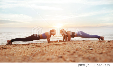Cheerful young caucasian women enjoy morning workout, doing plank exercise on sea beach, panorama, full length. Body care together, weight loss, sports and fit lifestyle outdoor Cheerful young caucasian women enjoy morning workout, doing plank exercise on sea beach, panorama, full length. Body care together, weight loss, sports and fit lifestyle outdoor 115639379