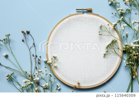 Flat lay composition with embroidery hoop and dried flowers on a light background 115640309