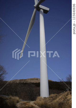 快晴の空にそびえ立つ風力発電の風車 115640696