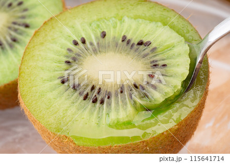 ジューシーなキウイフルーツをスプーンで食べる 115641714
