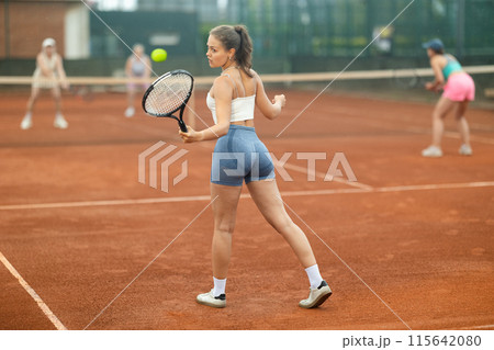 Emotional fit young girl playing doubles tennis on outdoor court Emotional fit young girl playing doubles tennis on outdoor court 115642080