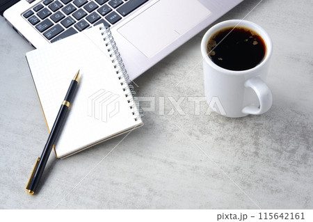机にノートパソコンやノートを広げ、コーヒーを飲みながらデスクワークをしているイメージ 机にノートパソコンやノートを広げ、コーヒーを飲みながらデスクワークをしているイメージ 115642161