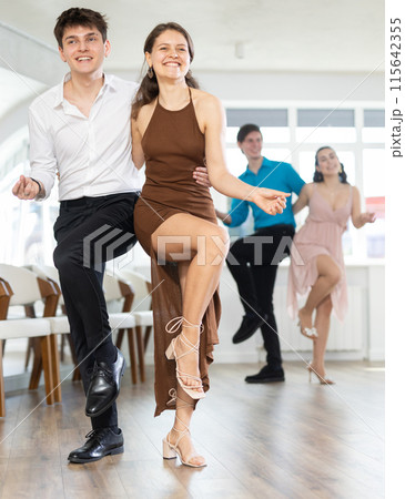 Cheerful young couple dancing vigorous lindy hop at group rehearsal 115642355