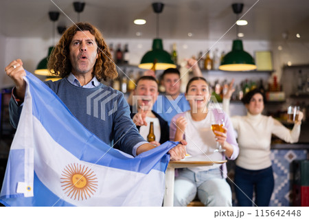 Happy fans celebrating the victory of Argentinean team in bar 115642448