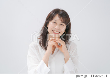 頬杖をつく笑顔のミドル女性 115642521