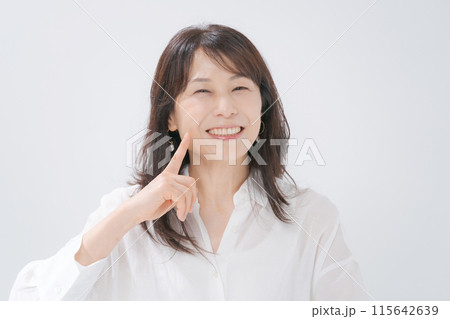 口元を指差すミドル女性 115642639