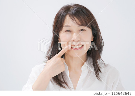 口元を指差すミドル女性 口元を指差すミドル女性 115642645
