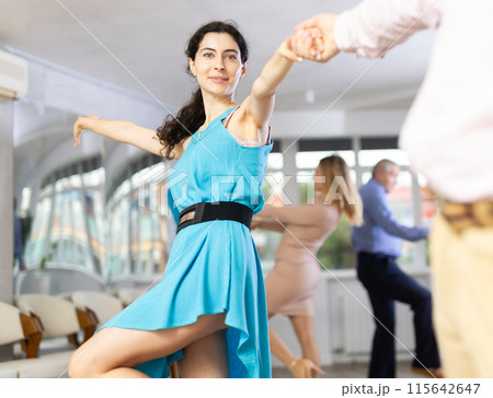 Positive pairs practicing vigorous jive movements in dance class Positive pairs practicing vigorous jive movements in dance class 115642647
