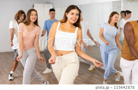 Women and man performing modern dance in fitness studio Women and man performing modern dance in fitness studio 115642878