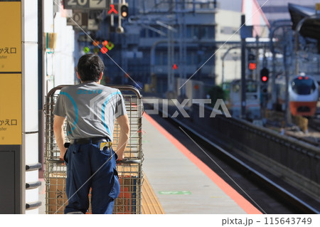 新幹線ホームで荷物を運ぶ駅員 新幹線ホームで荷物を運ぶ駅員 115643749