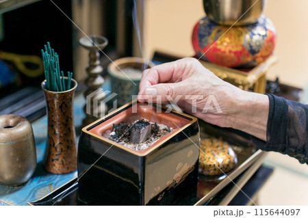 仏壇の前でお香を焚くシニア女性 115644097