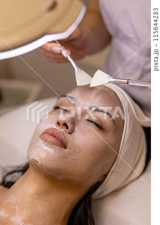 A girl at a cosmetologist does cosmetic procedures. Skin cleansing 115644283