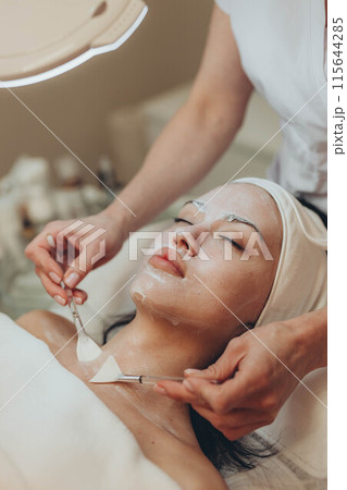 A girl at a cosmetologist does cosmetic procedures. Skin cleansing 115644285