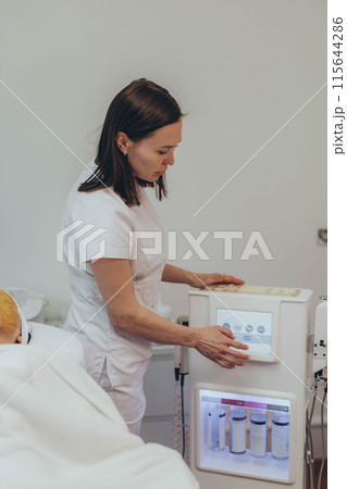 Cosmetologist esthetician performs skin treatment and rejuvenation 115644286