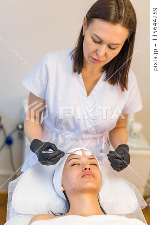 A girl at a cosmetologist does cosmetic procedures. Skin cleansing A girl at a cosmetologist does cosmetic procedures. Skin cleansing 115644289