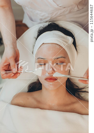 woman at the cosmetologist. She has problem skin and acne. 115644687