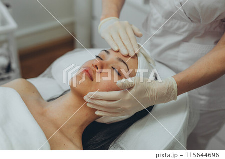 girl at a cosmetologist's office doing skin cleansing girl at a cosmetologist's office doing skin cleansing 115644696