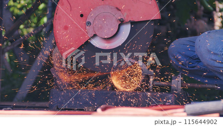 Welding machine iron metal sparking. Hot flame welding metal work cutting fire iron workshop. Locksmith using Welding machine cutting metal processing grinder. Close up hands Sparks in metalworking 115644902