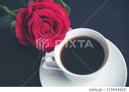 Tabletop black coffee cup red rose on wood table background with empty copy space. Espresso shot caffeine hot coffee cup in cafe. Top view Black caffeine dark beverage in cafeteria with copy space Tabletop black coffee cup red rose on wood table background with empty copy space. Espresso shot caffeine hot coffee cup in cafe. Top view Black caffeine dark beverage in cafeteria with copy space 115644928