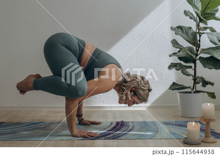 A 50-year-old woman does yoga at home A 50-year-old woman does yoga at home 115644938