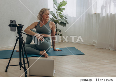 A 50-year-old woman doing online yoga at home A 50-year-old woman doing online yoga at home 115644980