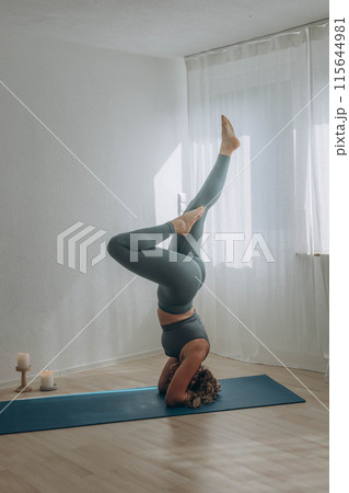 A 50-year-old woman does yoga at home A 50-year-old woman does yoga at home 115644981