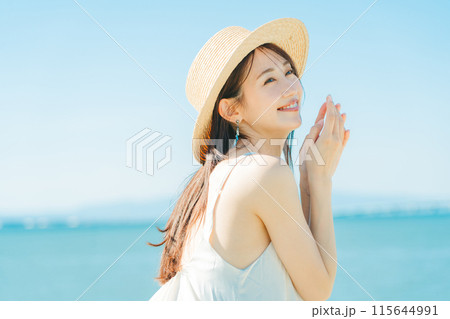 海と青空バックの麦わら帽子を被った女性 115644991