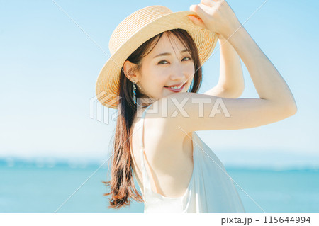 海と青空バックの麦わら帽子を被った女性 115644994