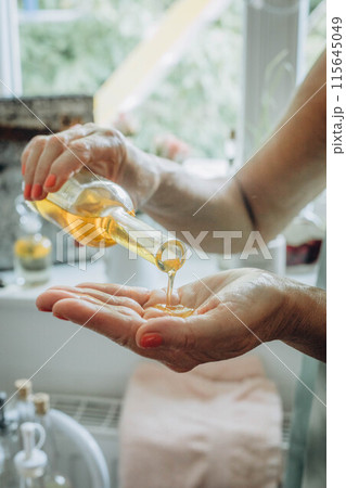 Massage oil trickles onto a hand, creating a serene moment of relaxation and pampering Massage oil trickles onto a hand, creating a serene moment of relaxation and pampering 115645049