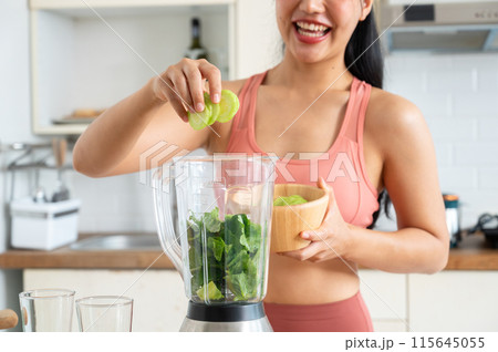 A cropped image of a fit and healthy Asian woman making a green smoothie in the kitchen. A cropped image of a fit and healthy Asian woman making a green smoothie in the kitchen. 115645055