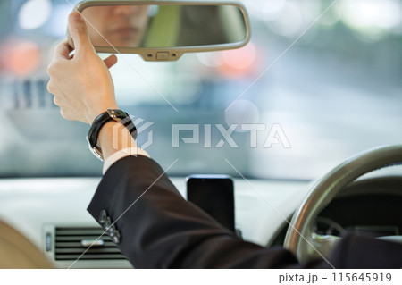ハンドルを握るスーツの若い男性 115645919