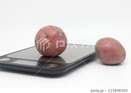 Fresh natural potatoes on electronic kitchen scales. Raw materials for making potato chips Fresh natural potatoes on electronic kitchen scales. Raw materials for making potato chips 115646505