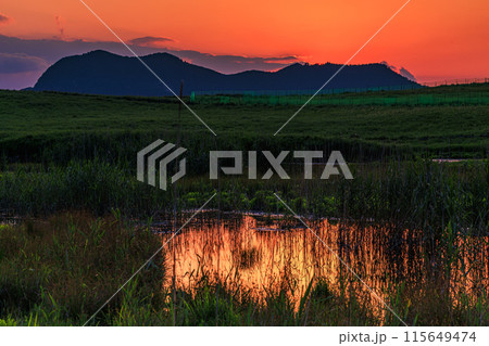 奈良と三重の県境曽爾高原の夕景　山際に沈んだ夕日と黄金色に染まる高原① 115649474