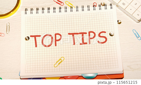 Business concept. Text TOP TIPS in a notebook on the desk of a businessman, manager Business concept. Text TOP TIPS in a notebook on the desk of a businessman, manager 115651215
