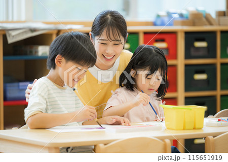 学童や放課後デイサービス等で勉強をする先生と生徒 小学生複数と見守る先生 学童や放課後デイサービス等で勉強をする先生と生徒 小学生複数と見守る先生 115651919
