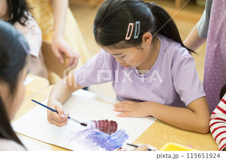 絵具で絵を描く小学生の子供　女の子　学校や学童、放課後デイサービスなどのイメージ　俯瞰 115651924