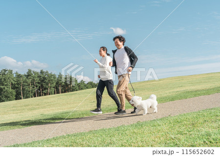 公園で犬の散歩をする家族・夫婦・カップル・男女（走る・ジョギング・ランニング） 115652602