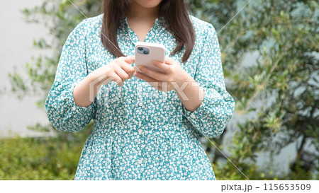 街角でスマホを使用する若い女性 115653509