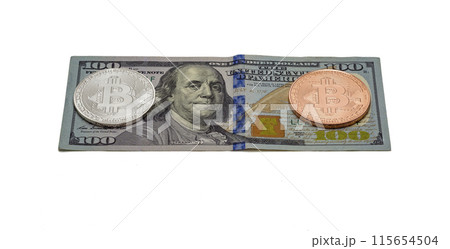 Silver and platinum coin Bitcoin lies on a hundred dollar bill. On the bill a hundred dollars are two coins of Bitcoin, silver and platinum 115654504